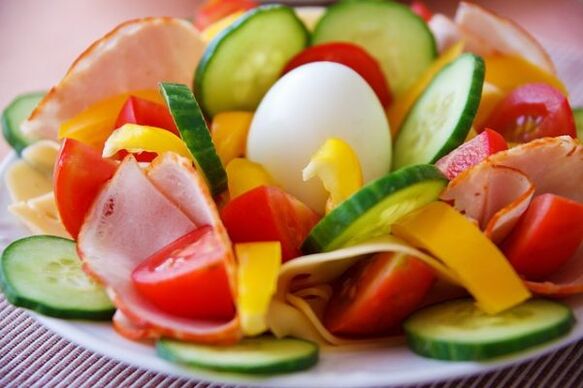 Ensalada de verduras en el menú dietético con huevos y naranjas para adelgazar. 